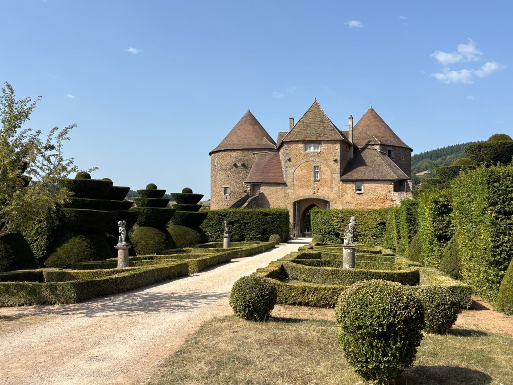 Il torrione d'ingresso della Forteresse de Berzé e il giardino alla francese con i tassi potati