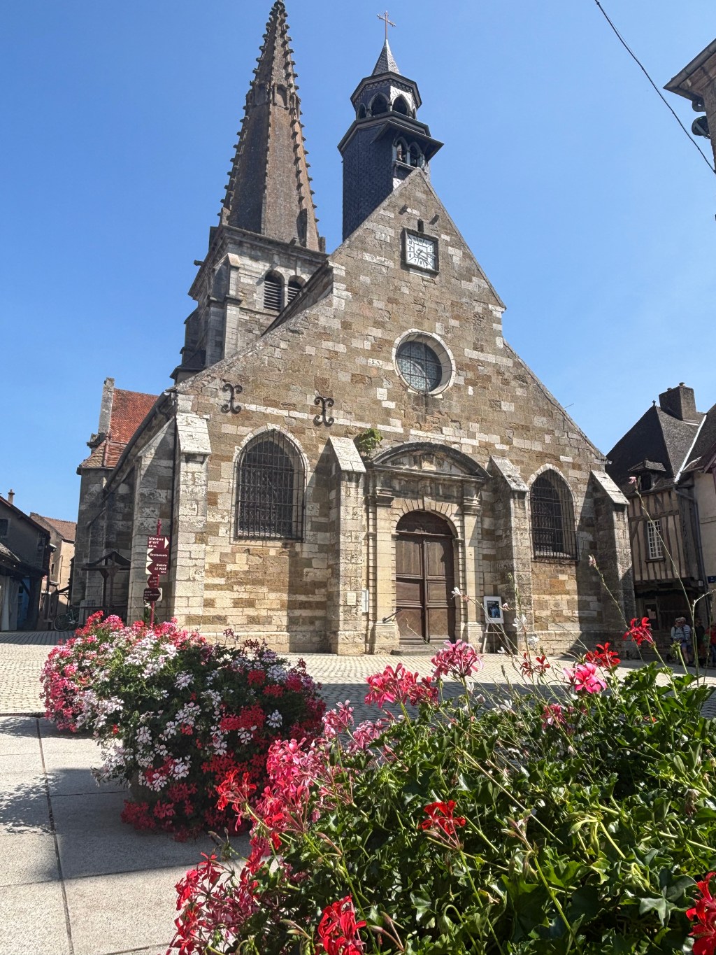 La chiesa di Saint-Martin a Nolay con il campanile, tra le aiuole fiorite
